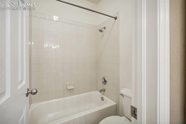 bathroom featuring toilet and tiled shower / bath