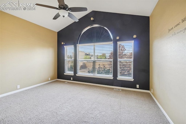 carpeted spare room featuring ceiling fan and vaulted ceiling