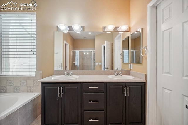 bathroom featuring shower with separate bathtub and vanity