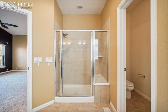 bathroom with tile patterned flooring, ceiling fan, walk in shower, and toilet