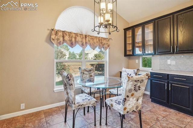 dining area with plenty of natural light, vaulted ceiling, and a chandelier