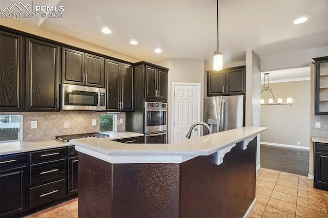 kitchen featuring pendant lighting, dark brown cabinetry, appliances with stainless steel finishes, and a kitchen island