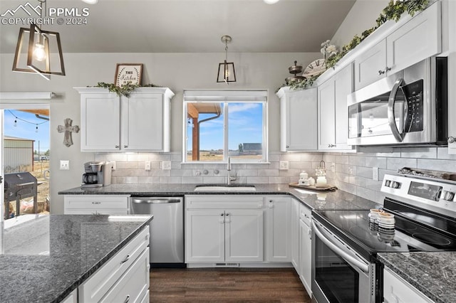 kitchen featuring hanging light fixtures, white cabinets, and appliances with stainless steel finishes