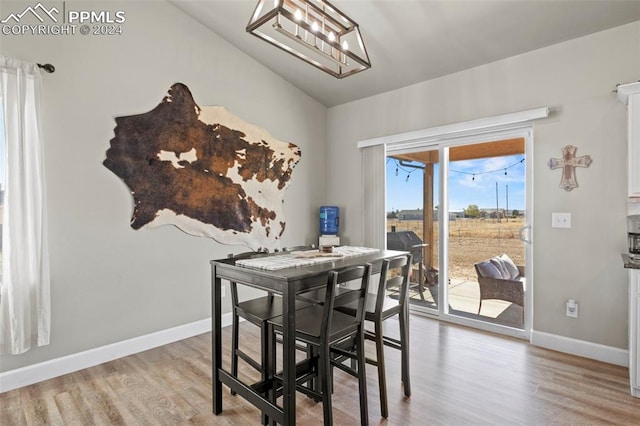 dining room with lofted ceiling and wood-type flooring