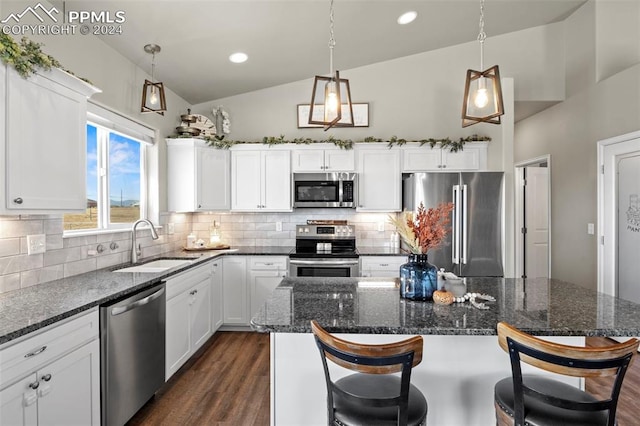 kitchen featuring white cabinets, lofted ceiling, sink, backsplash, and appliances with stainless steel finishes