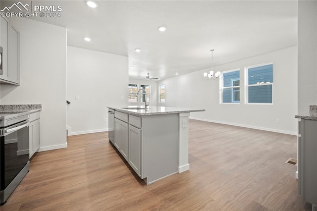 kitchen with sink, stainless steel appliances, light hardwood / wood-style floors, and a center island