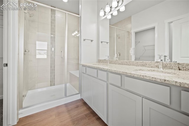 bathroom featuring vanity, hardwood / wood-style floors, and a shower with shower door