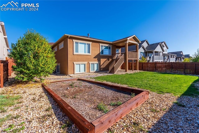 rear view of property featuring a yard and a wooden deck