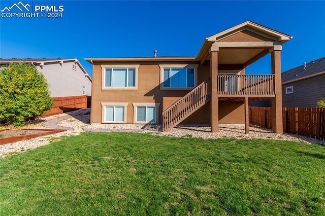 rear view of property featuring a deck and a yard