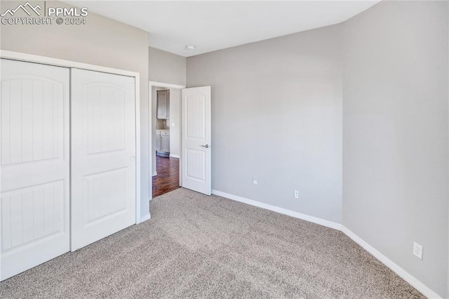 unfurnished bedroom with a closet and carpet