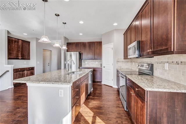 kitchen with an island with sink, appliances with stainless steel finishes, dark hardwood / wood-style floors, and sink