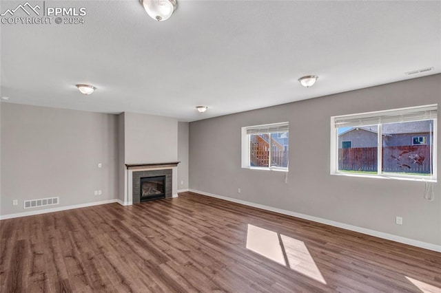 unfurnished living room featuring hardwood / wood-style flooring and a fireplace