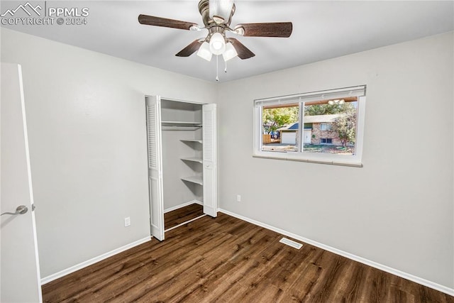 unfurnished bedroom with dark hardwood / wood-style flooring, a closet, and ceiling fan