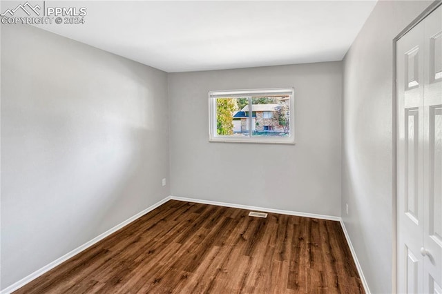 spare room with dark wood-type flooring