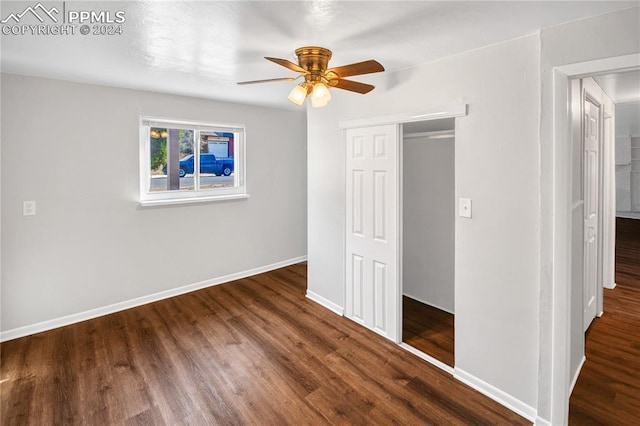 unfurnished bedroom featuring dark hardwood / wood-style flooring, a closet, and ceiling fan