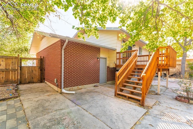 exterior space with a wooden deck and a patio