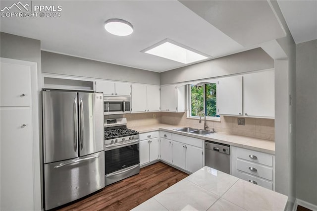 kitchen featuring white cabinets, tasteful backsplash, dark hardwood / wood-style flooring, sink, and stainless steel appliances