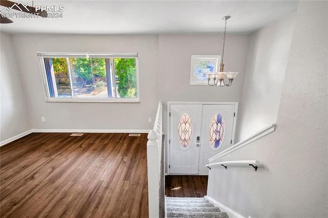 foyer with dark hardwood / wood-style floors and an inviting chandelier