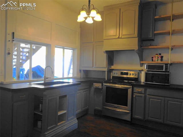 kitchen with hanging light fixtures, sink, appliances with stainless steel finishes, dark hardwood / wood-style floors, and a notable chandelier