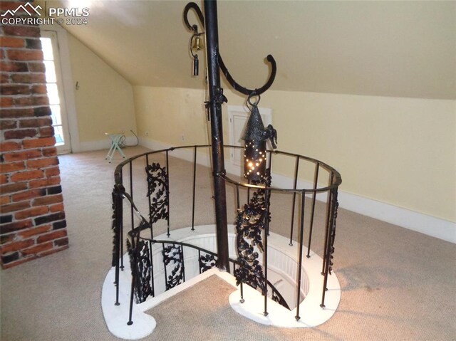 staircase with lofted ceiling and carpet floors