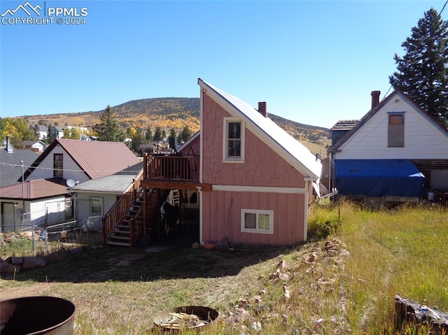 back of house featuring an outdoor fire pit and a mountain view