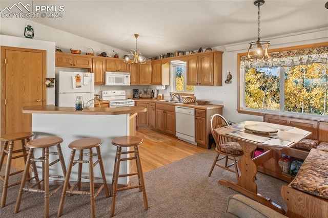 kitchen featuring lofted ceiling, a wealth of natural light, white appliances, and light hardwood / wood-style floors