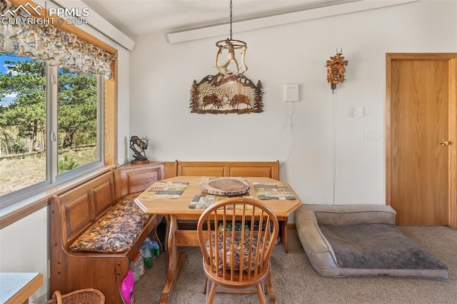 dining room featuring carpet and vaulted ceiling with beams