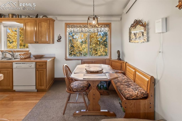 dining area with breakfast area, sink, and light hardwood / wood-style flooring