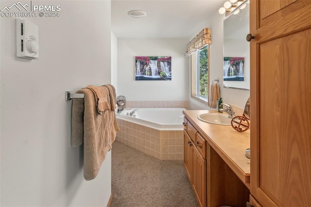 bathroom with vanity and a relaxing tiled tub