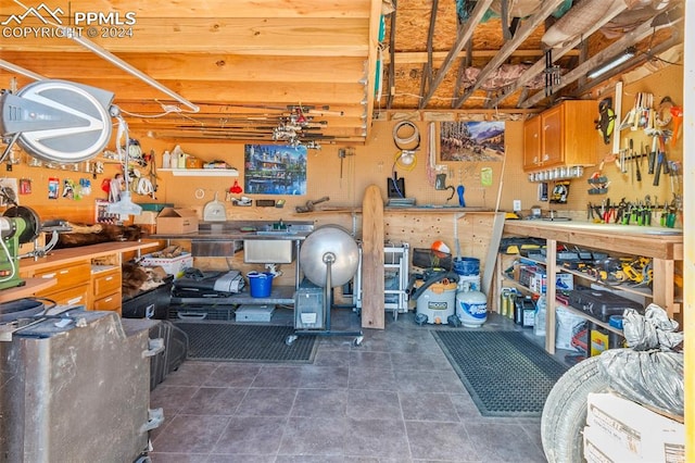 miscellaneous room with a workshop area and dark tile patterned floors