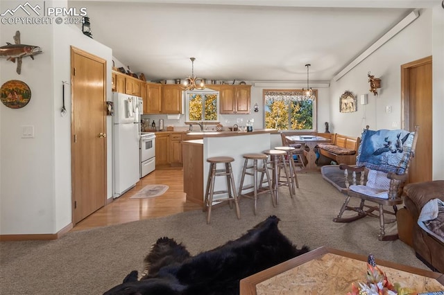 kitchen with hanging light fixtures, light hardwood / wood-style floors, a breakfast bar, white appliances, and a center island