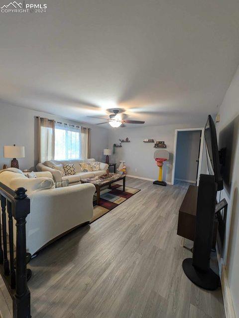 living room with hardwood / wood-style floors and ceiling fan