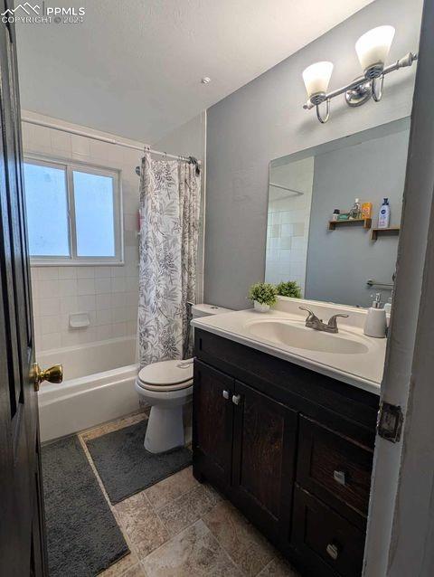 full bathroom featuring vanity, shower / bath combination with curtain, and toilet