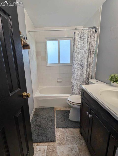 full bathroom with toilet, vanity, and shower / bath combination with curtain