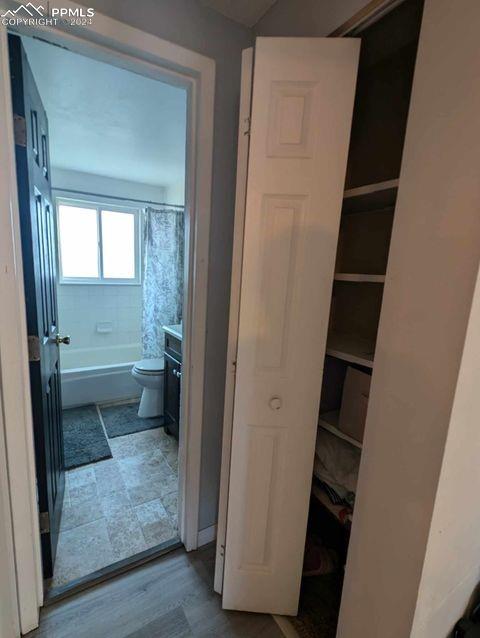 full bathroom with vanity, toilet, hardwood / wood-style flooring, and shower / bath combo with shower curtain