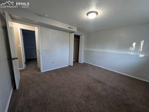 unfurnished bedroom featuring a closet, a textured ceiling, and dark carpet