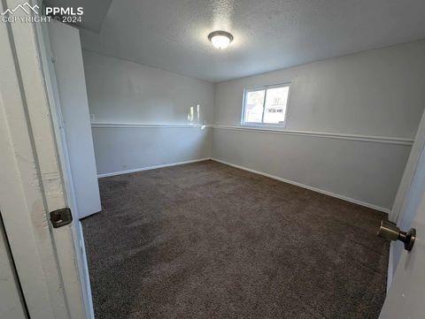 empty room featuring a textured ceiling and dark carpet