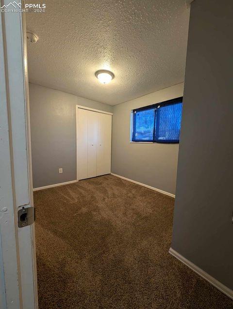 unfurnished bedroom featuring a closet, carpet floors, and a textured ceiling