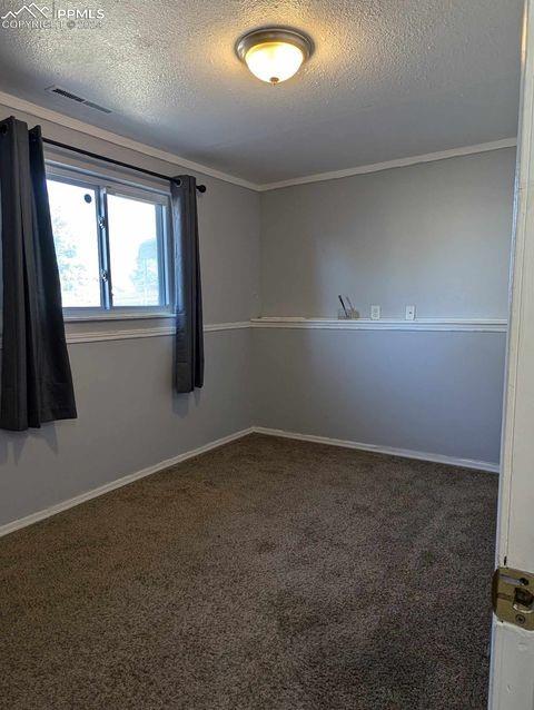 carpeted empty room featuring ornamental molding and a textured ceiling