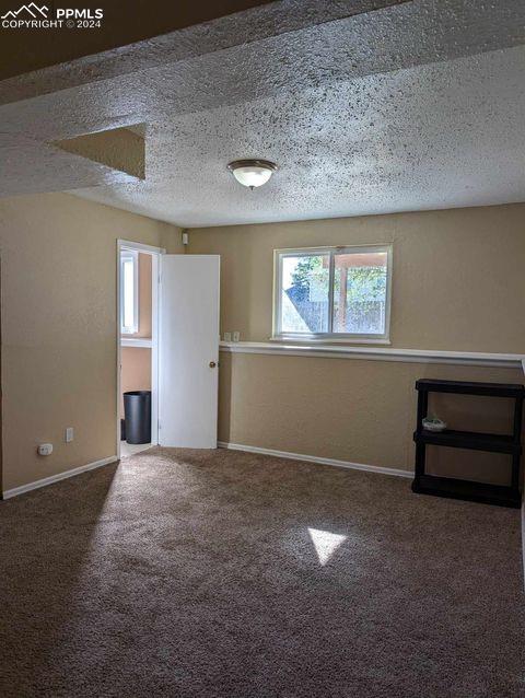 unfurnished room with a textured ceiling and carpet flooring