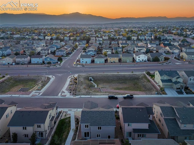 aerial view at dusk featuring a mountain view