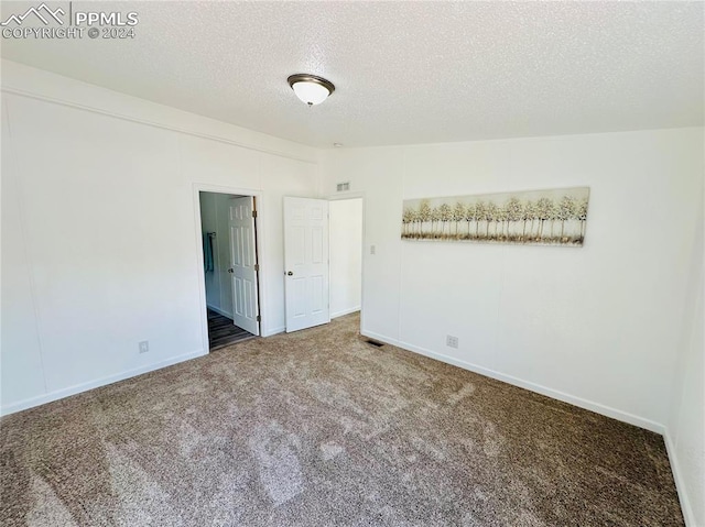 unfurnished bedroom featuring a textured ceiling and carpet flooring