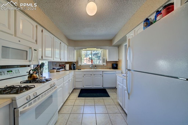 kitchen featuring sink, light tile patterned floors, white cabinetry, white appliances, and tasteful backsplash