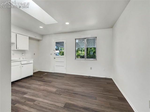 kitchen with white cabinetry, a skylight, and dark hardwood / wood-style flooring