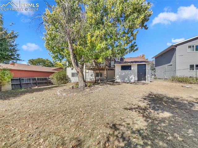 rear view of property featuring a storage shed