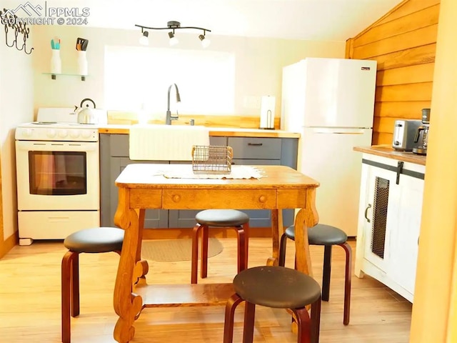 kitchen featuring light hardwood / wood-style floors, white appliances, sink, and gray cabinets