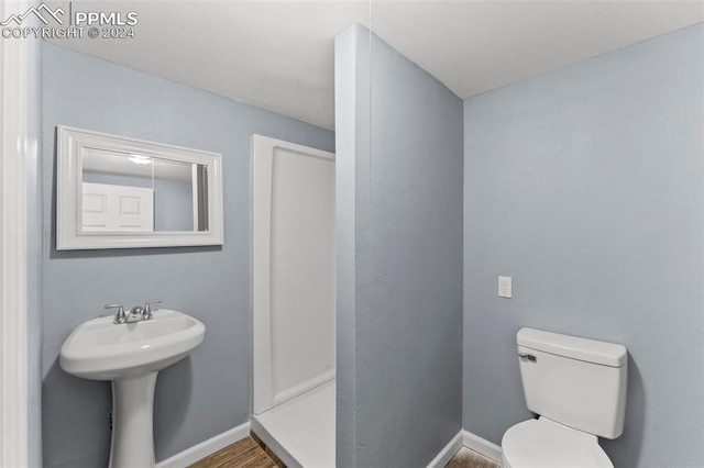 bathroom with hardwood / wood-style flooring, sink, and toilet