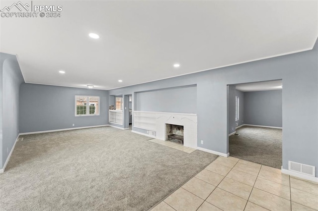 unfurnished living room featuring light colored carpet and a premium fireplace