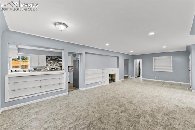 unfurnished living room with light colored carpet