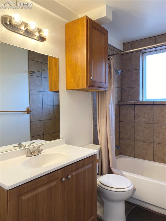 full bathroom with vanity, toilet, and shower / bathtub combination with curtain